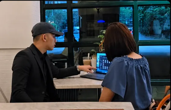 Jovit Ryan Lucero reviewing content with a client at a laptop